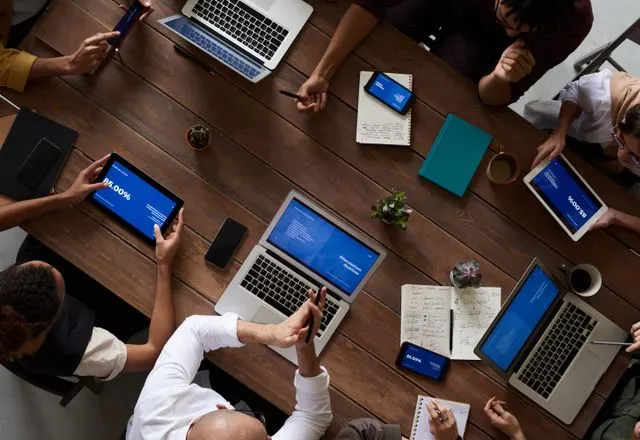 Team working around a table of laptops and tablets